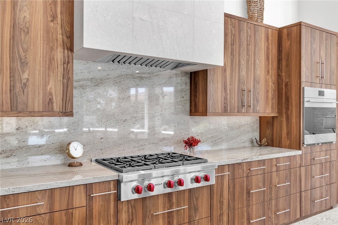 1508 Ten Palms Court, Las Vegas, NV 89117 Rich wood cabinetry surrounds a professional gas range and polished stone countertops.