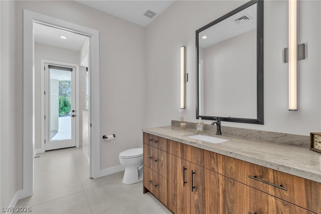 1508 Ten Palms Court, Las Vegas, NV 89117 Rich wood cabinetry contrasts with pale stone counters and clean tile flooring.