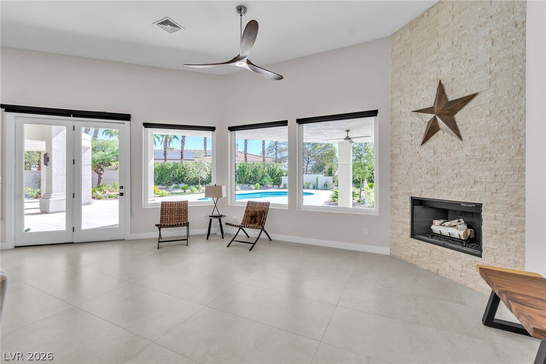 1508 Ten Palms Court, Las Vegas, NV 89117 A stone-clad fireplace highlights this airy living area overlooking the pool.