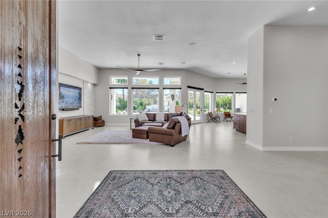 1508 Ten Palms Court, Las Vegas, NV 89117 An open entry reveals a sprawling main living space framed by towering windows.