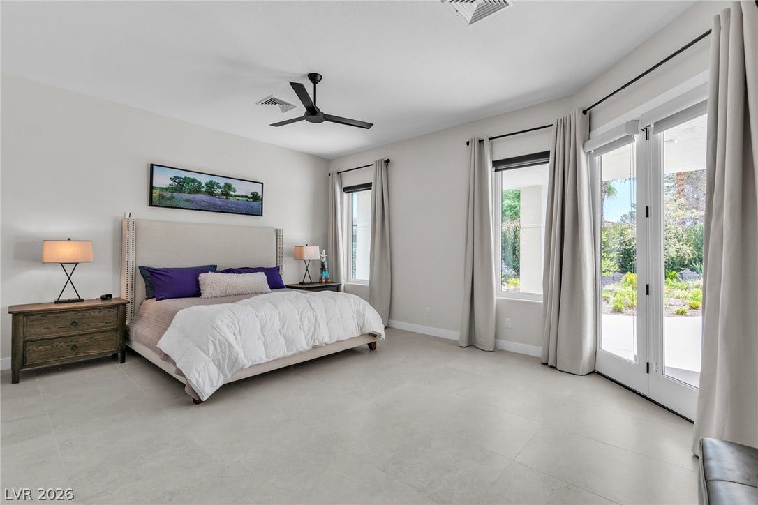 1508 Ten Palms Court, Las Vegas, NV 89117 A spacious bedroom features large format tile flooring and glass doors leading outside.