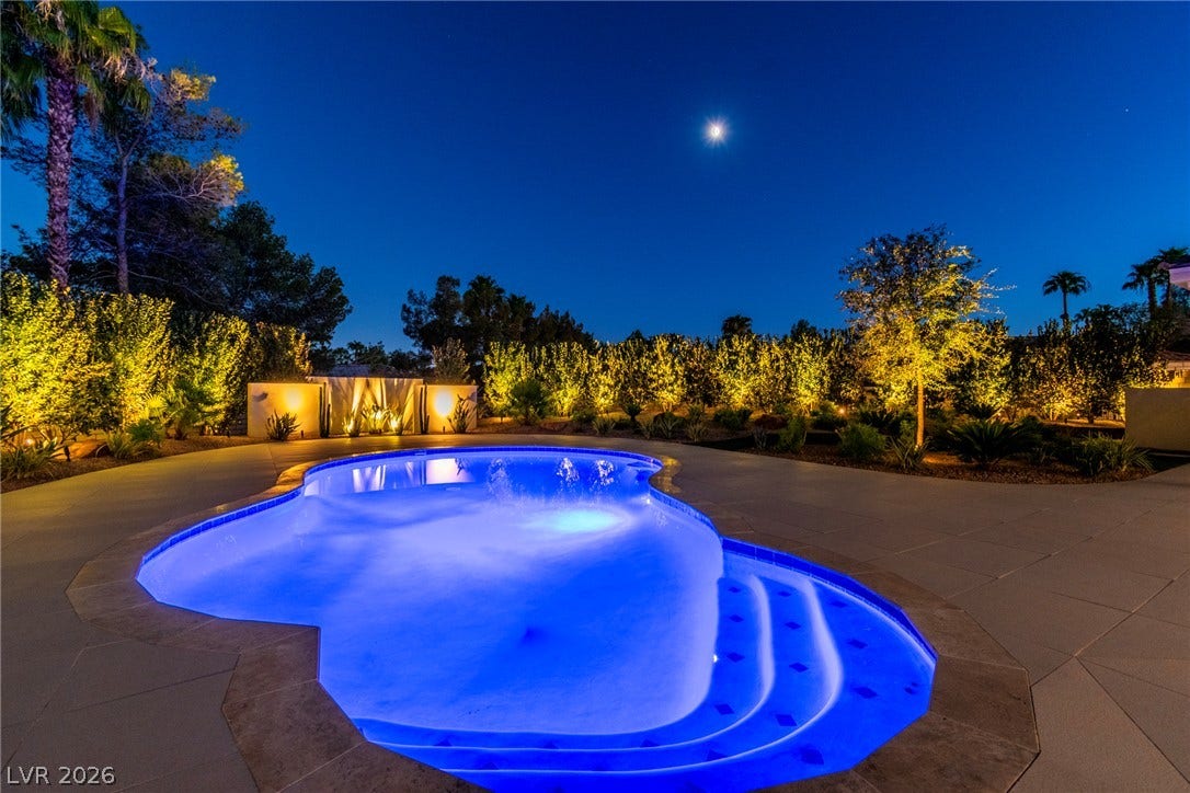 1508 Ten Palms Court, Las Vegas, NV 89117 An inviting swimming pool glows beneath the night sky, surrounded by manicured landscaping.