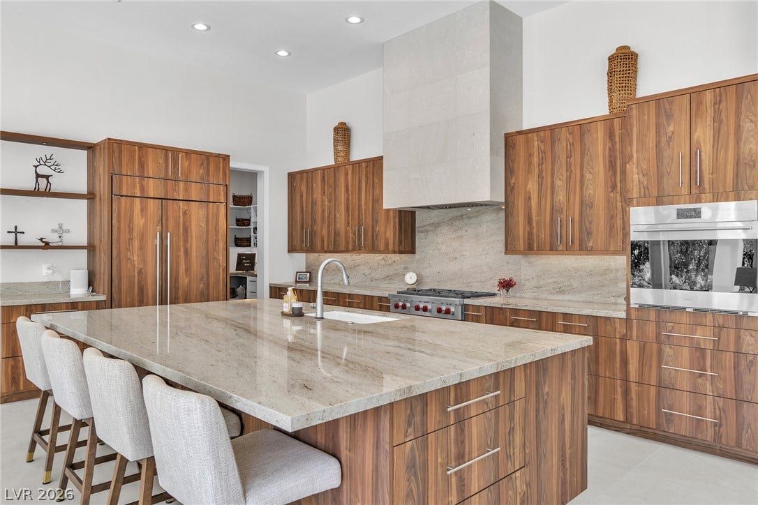 1508 Ten Palms Court, Las Vegas, NV 89117 Rich wood cabinetry contrasts beautifully with expansive stone countertops in this modern gourmet kitchen.