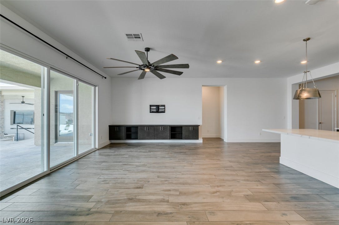 11288 Rebel Dome Court, Las Vegas, NV 89141 Wood-look tile flooring and sliding glass doors define this open living and dining area.