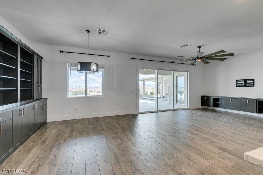 11288 Rebel Dome Court, Las Vegas, NV 89141 Sliding glass doors open to a spacious patio from this versatile living area with wood-look flooring.