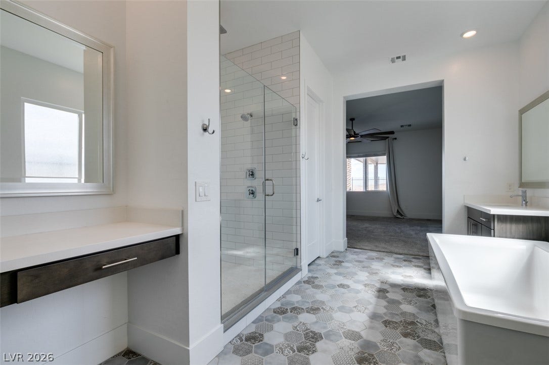 11288 Rebel Dome Court, Las Vegas, NV 89141 Patterned hexagon tile flooring pairs with a glass-enclosed shower and a freestanding tub.