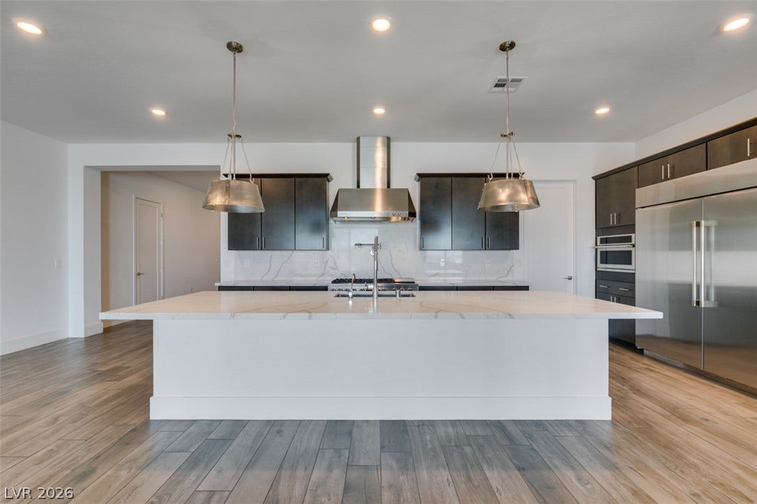 11288 Rebel Dome Court, Las Vegas, NV 89141 An expansive kitchen island highlights this modern culinary space anchored by sleek wood flooring.