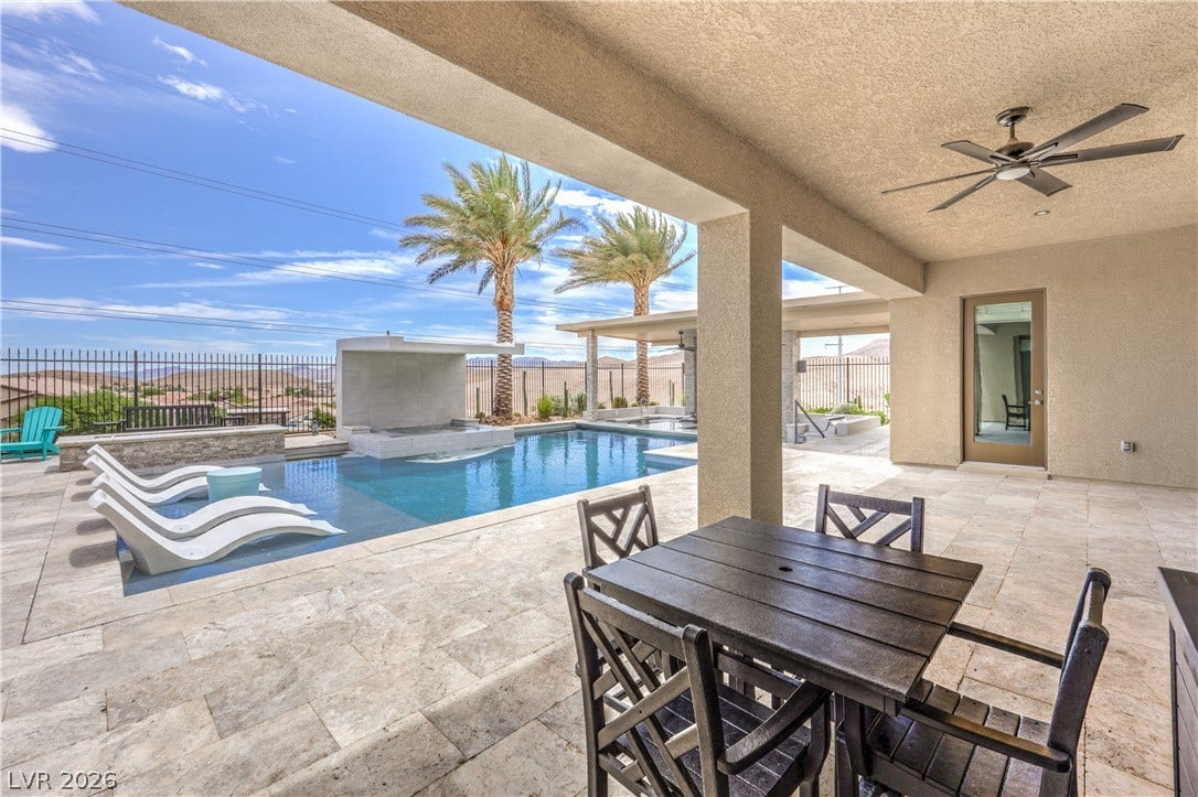 11288 Rebel Dome Court, Las Vegas, NV 89141 An inviting covered patio steps down to a sparkling pool set against desert mountain views.