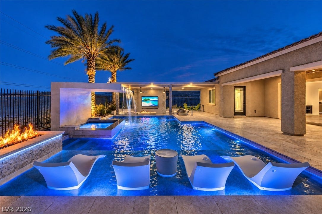 11288 Rebel Dome Court, Las Vegas, NV 89141 An inviting backyard oasis features a custom swimming pool paired with an integrated fire pit.