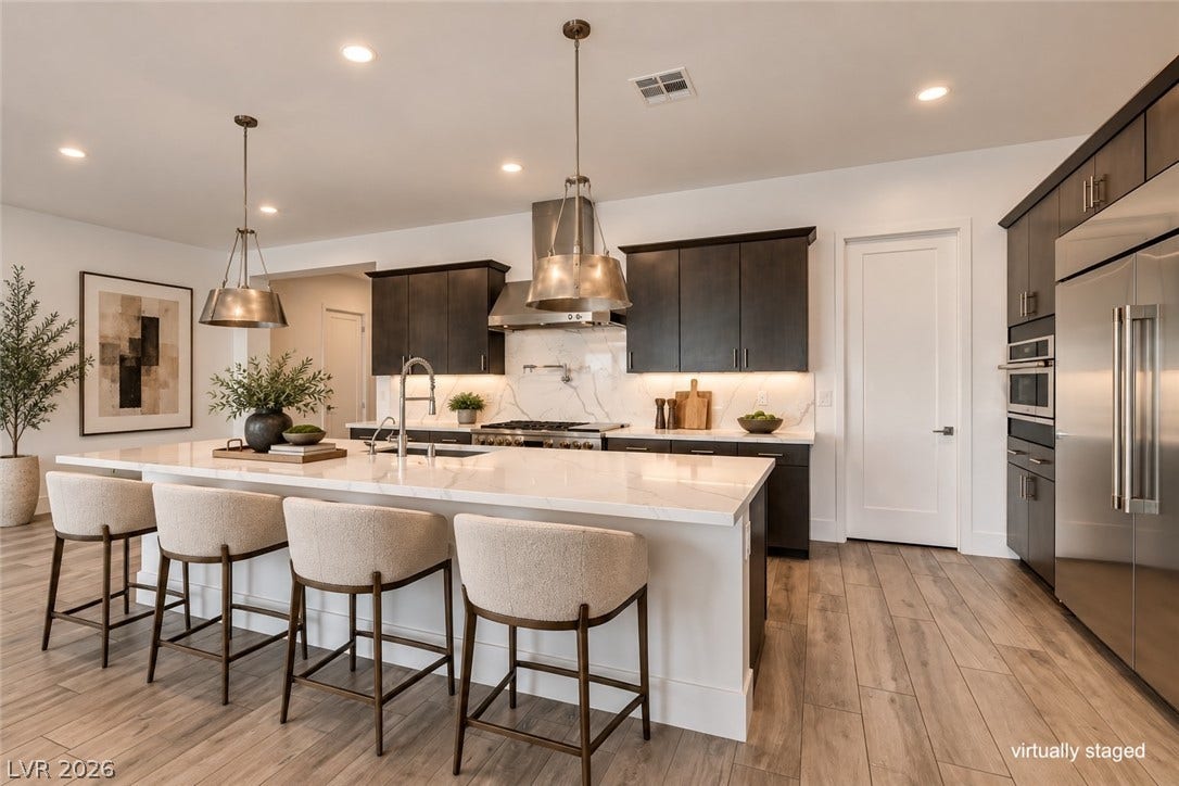11288 Rebel Dome Court, Las Vegas, NV 89141 An open kitchen design balances rich dark cabinetry against gleaming stone countertops and wood flooring.