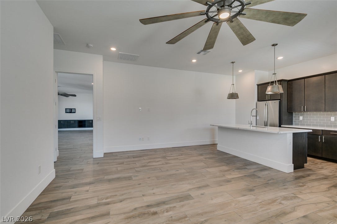 11288 Rebel Dome Court, Las Vegas, NV 89141 Clean lines and wood-look flooring define this open-concept kitchen and living area.