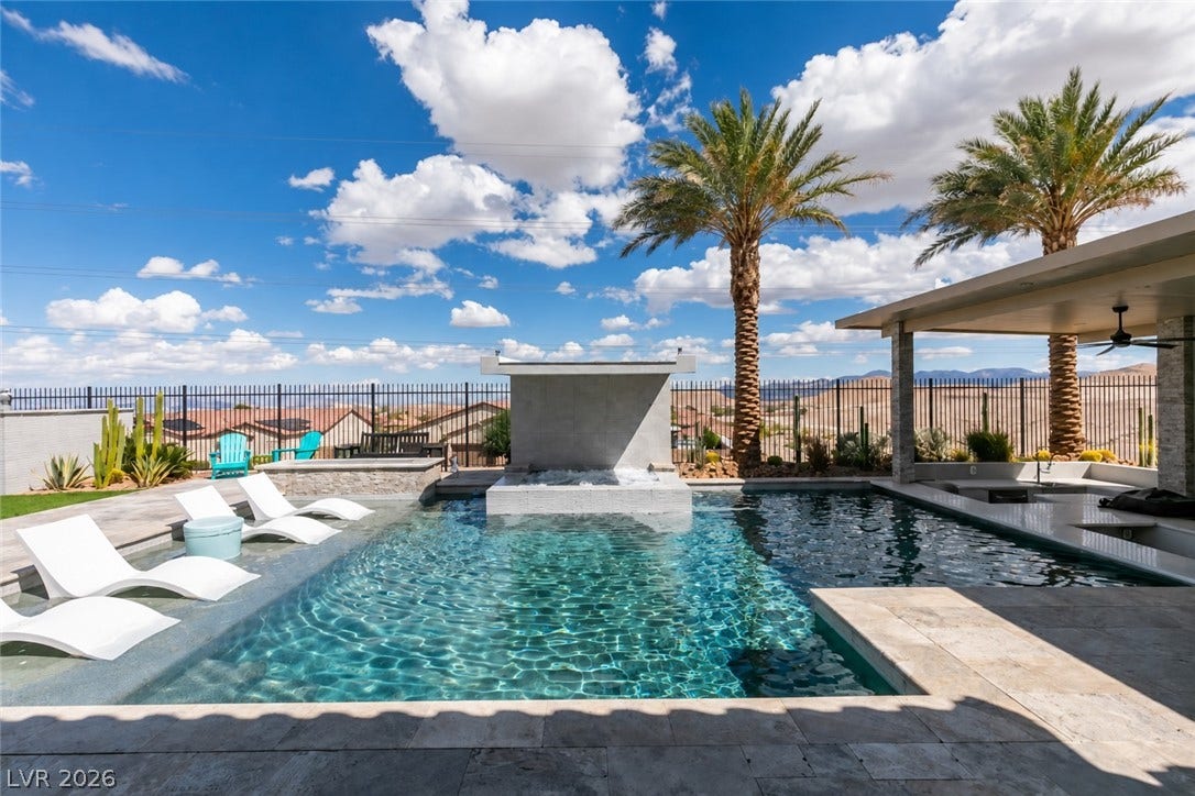 11288 Rebel Dome Court, Las Vegas, NV 89141 An inviting backyard oasis features a shimmering swimming pool with built-in lounge seating and water features.