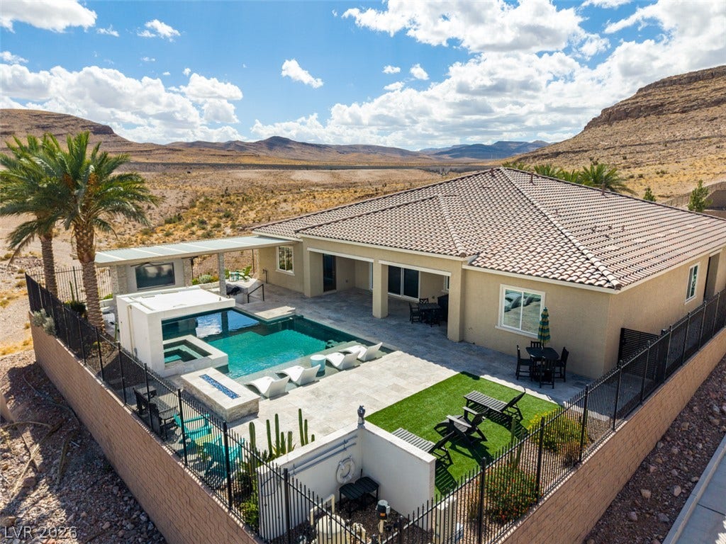 11288 Rebel Dome Court, Las Vegas, NV 89141 An inviting backyard oasis features a swimming pool set against a dramatic desert mountain backdrop.