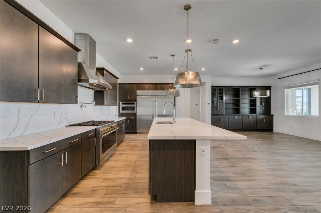 11288 Rebel Dome Court, Las Vegas, NV 89141 Sleek modern cabinetry pairs beautifully with expansive stone countertops in this airy kitchen.