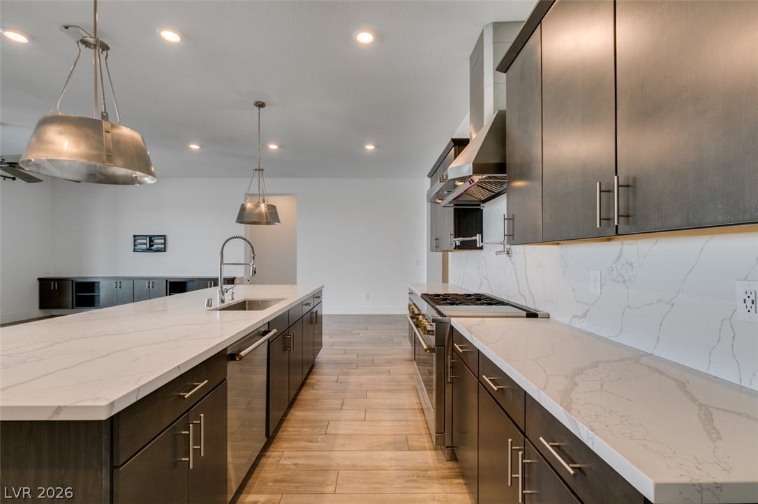 11288 Rebel Dome Court, Las Vegas, NV 89141 Gleaming stone countertops and sleek modern cabinetry anchor this expansive culinary space.