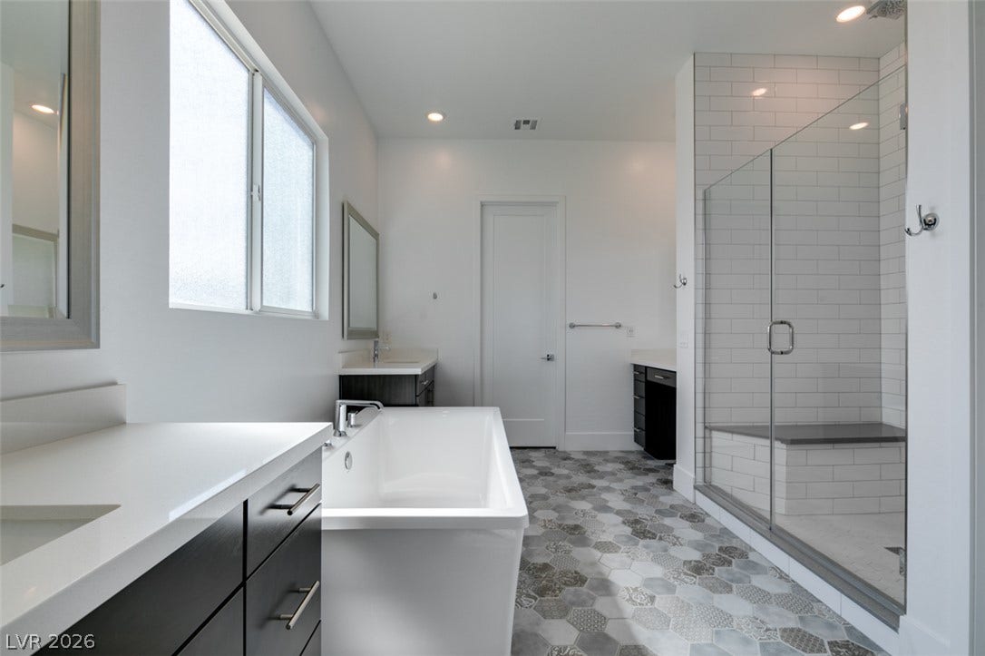 11288 Rebel Dome Court, Las Vegas, NV 89141 Patterned tile floors and a glass-enclosed shower elevate this modern bathroom.