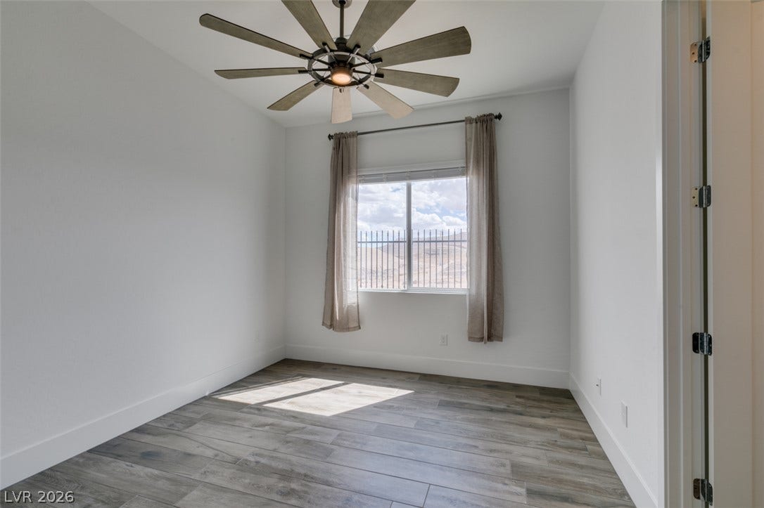 11288 Rebel Dome Court, Las Vegas, NV 89141 Plank flooring and smooth plaster walls define this versatile secondary bedroom space.