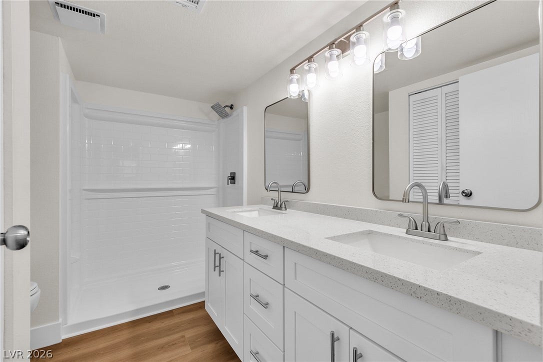 A sleek double vanity paired with a modern walk-in shower highlights this contemporary bathroom design.