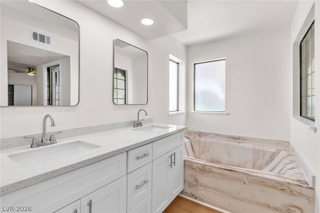 Clean lines and a luxurious soaking tub define this modern primary bath sanctuary.