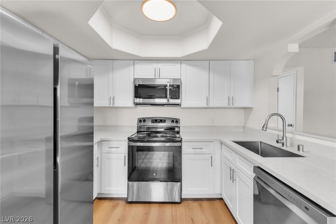 Gleaming stone countertops and stainless steel appliances elevate this bright, functional kitchen space.