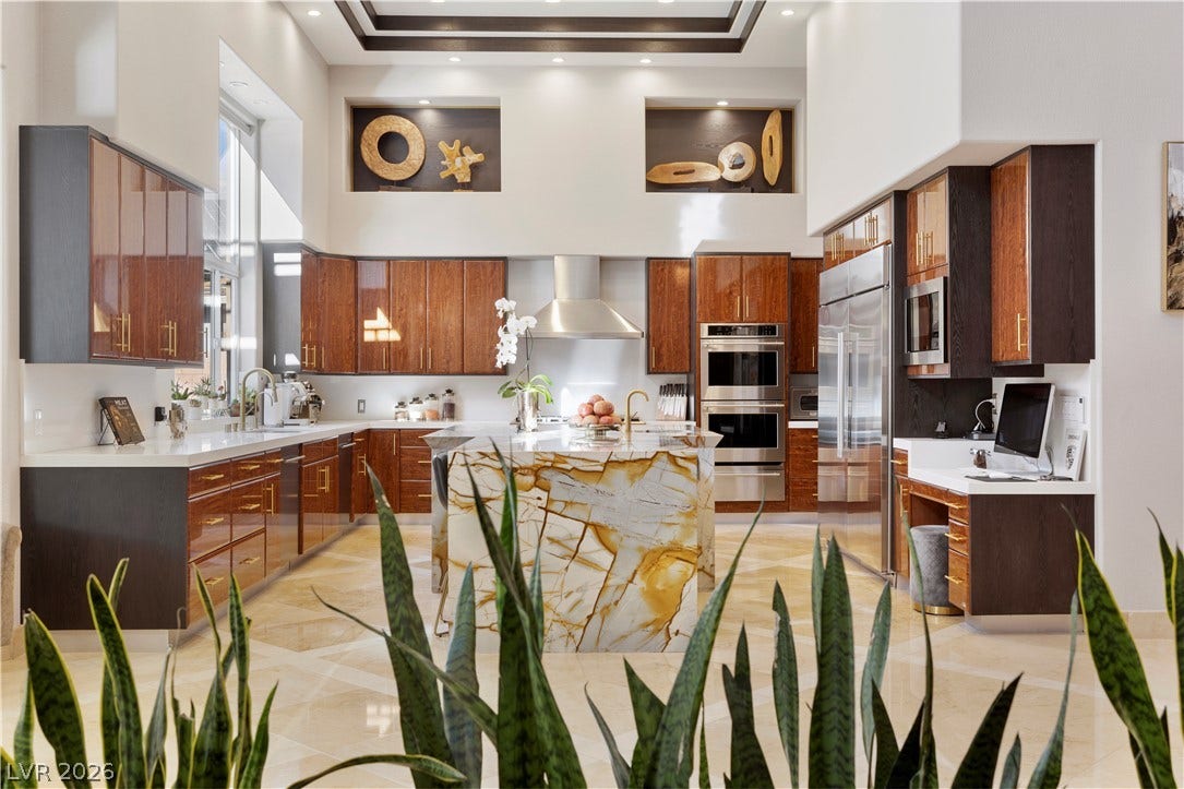 9624 Grand Isle Lane, Las Vegas, NV 89144 Gleaming stone tile floors and rich wood cabinetry anchor this grand kitchen under towering ceilings.