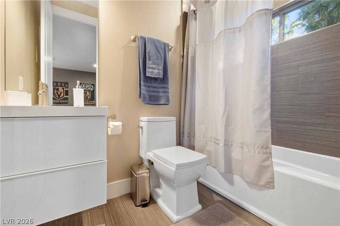 9624 Grand Isle Lane, Las Vegas, NV 89144 Modern finishes define this bathroom featuring textured wall tile and a sleek white floating vanity.
