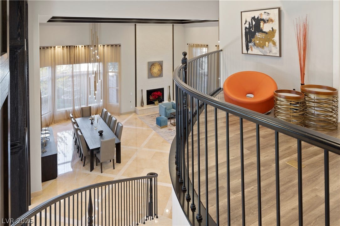 9624 Grand Isle Lane, Las Vegas, NV 89144 An elegant curved staircase overlooks the open-concept dining area and living room below.