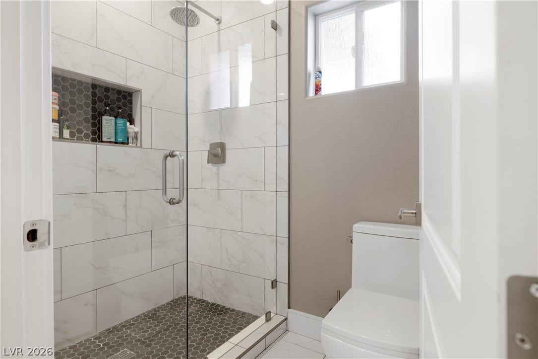 9624 Grand Isle Lane, Las Vegas, NV 89144 Tiled walk-in shower features glass doors and modern finishes in this refined bathroom space.