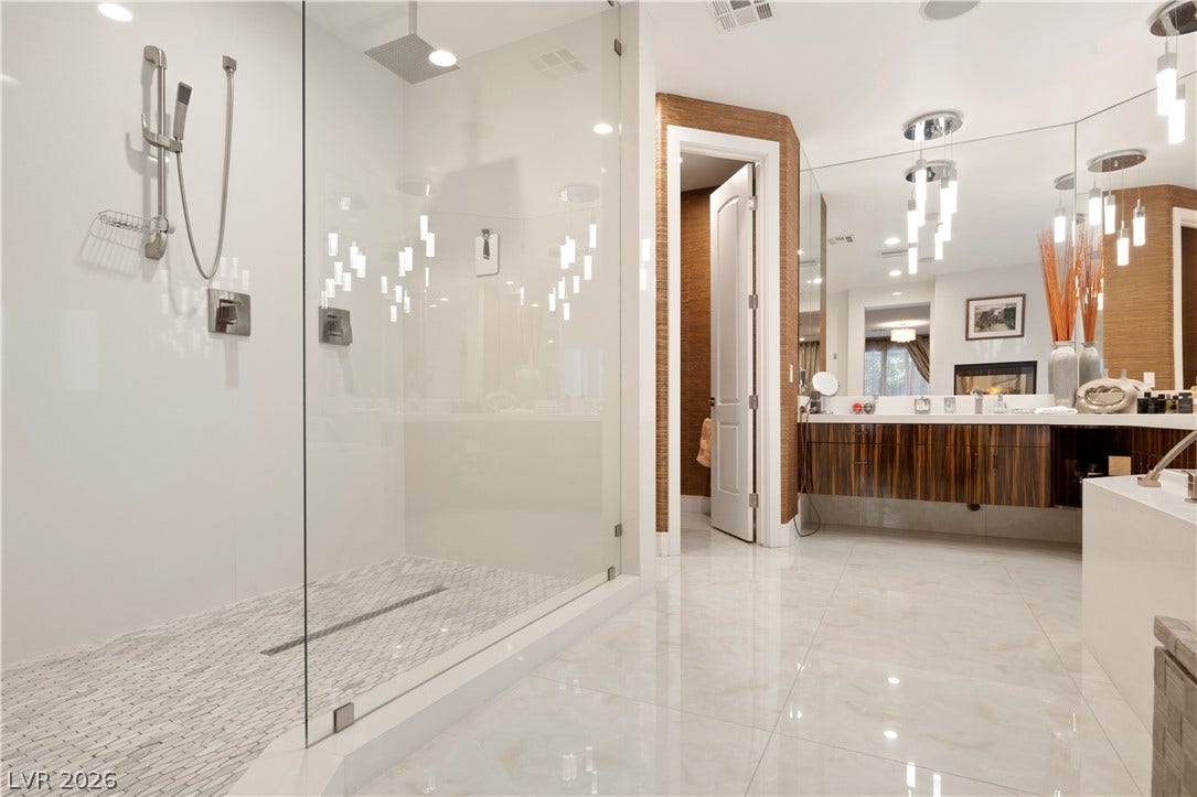 9624 Grand Isle Lane, Las Vegas, NV 89144 Polished tile flooring and a frameless glass shower define this contemporary bathroom space.