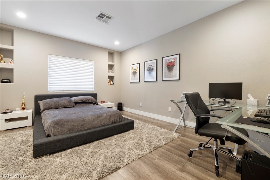 9624 Grand Isle Lane, Las Vegas, NV 89144 Smooth wood flooring and built-in wall shelving highlight this versatile, modern bedroom.