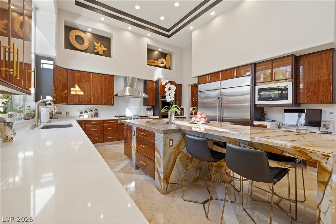 9624 Grand Isle Lane, Las Vegas, NV 89144 High ceilings and a dramatic stone island anchor this chef-worthy kitchen design.