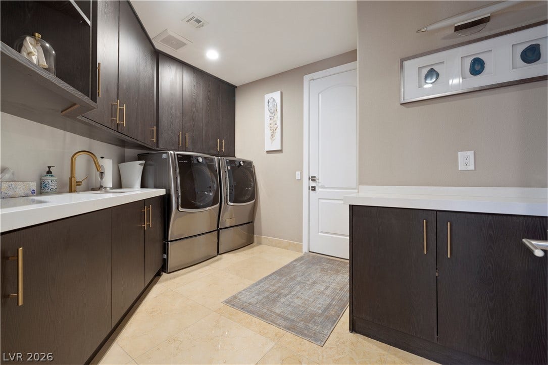 9624 Grand Isle Lane, Las Vegas, NV 89144 Ample dark cabinetry, sleek solid-surface countertops, and tiled floors define this functional utility space.