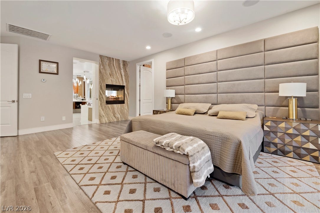 9624 Grand Isle Lane, Las Vegas, NV 89144 A stone-surround fireplace and wood floors highlight this modern primary suite.