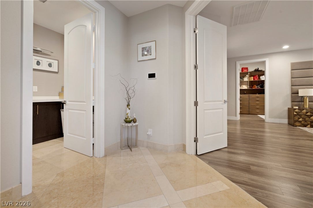 9624 Grand Isle Lane, Las Vegas, NV 89144 Polished tile and warm wood floors define this transitions-filled hallway layout.