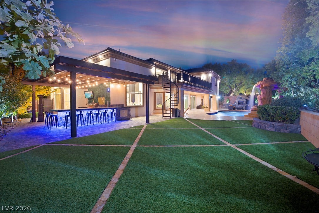 9624 Grand Isle Lane, Las Vegas, NV 89144 An inviting backyard oasis features a manicured lawn alongside an integrated pool and patio area.