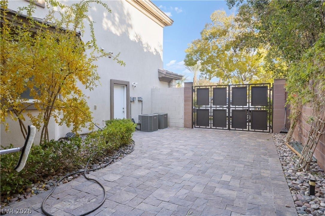 9624 Grand Isle Lane, Las Vegas, NV 89144 An expansive paved courtyard is enclosed by a secure decorative gate and mature landscaping.
