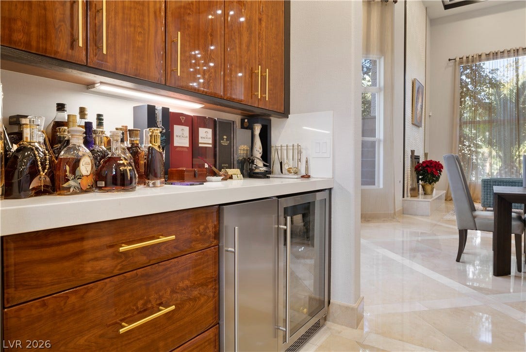 9624 Grand Isle Lane, Las Vegas, NV 89144 Rich wood cabinetry and integrated cooling highlight this elegant wet bar area.