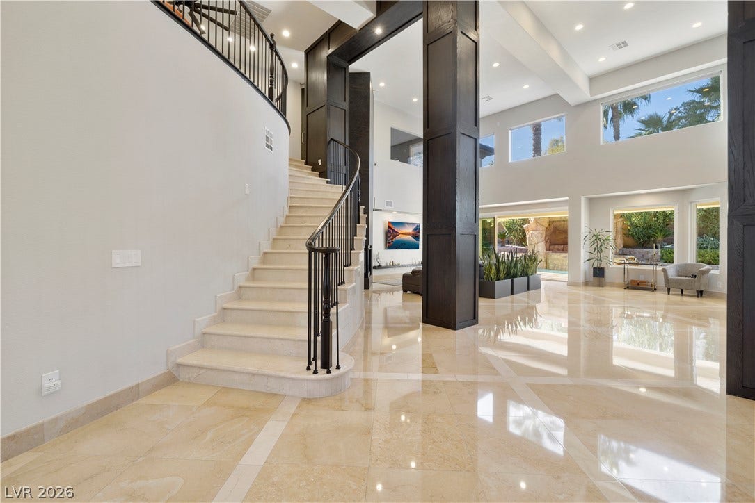 9624 Grand Isle Lane, Las Vegas, NV 89144 Polished stone flooring and a sweeping staircase anchor this grand double-height entrance hall.