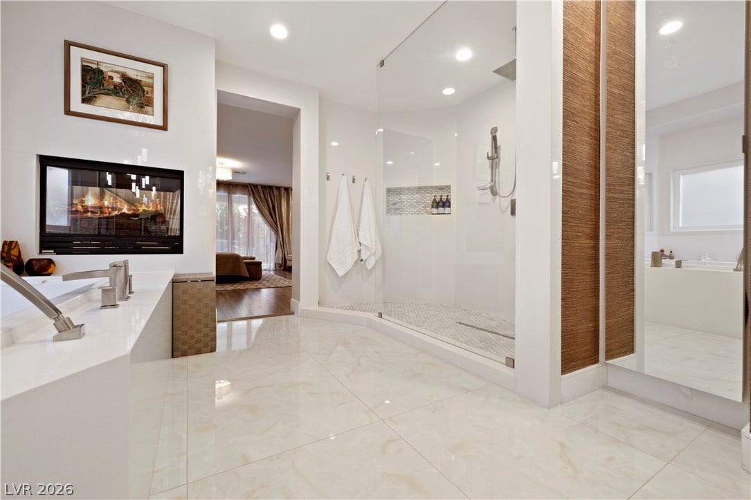 9624 Grand Isle Lane, Las Vegas, NV 89144 Polished tile flooring and a sleek glass-enclosed shower define this luxurious modern bath space.