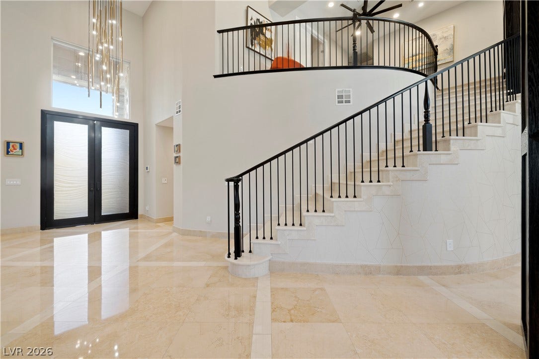 9624 Grand Isle Lane, Las Vegas, NV 89144 Polished tile flooring and a curved staircase define this grand multi-level entryway.
