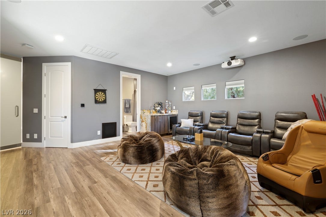 9624 Grand Isle Lane, Las Vegas, NV 89144 Recessed lighting and warm wood-style flooring elevate this spacious media room layout.