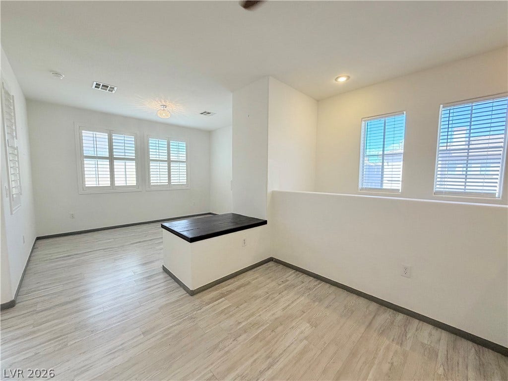 10221 Deerfield Beach Avenue, #202, Las Vegas, NV 89129 An open upstairs loft area boasts wood flooring and abundant natural light through multiple windows.