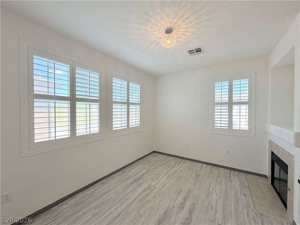 10221 Deerfield Beach Avenue, #202, Las Vegas, NV 89129 Clean lines and classic shutters frame a versatile space anchored by a cozy fireplace.