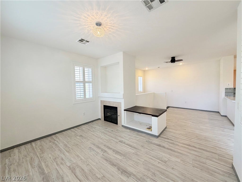 10221 Deerfield Beach Avenue, #202, Las Vegas, NV 89129 Clean lines and light flooring define this open living space anchored by a central fireplace.