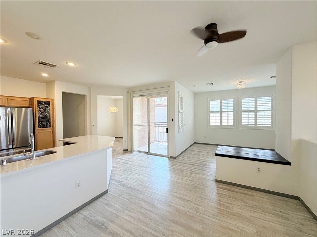 10221 Deerfield Beach Avenue, #202, Las Vegas, NV 89129 Clean lines and light flooring define this open-concept main living area with backyard access.