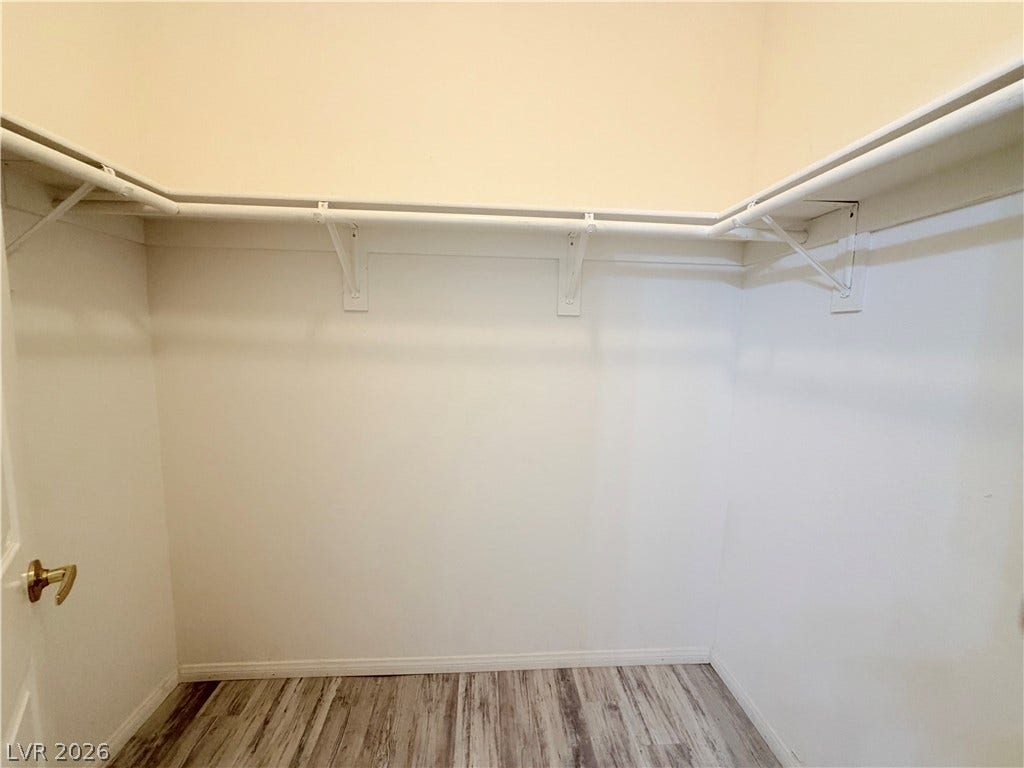 10221 Deerfield Beach Avenue, #202, Las Vegas, NV 89129 Generous closet space featuring built-in shelving, hanging rods, and modern plank flooring.