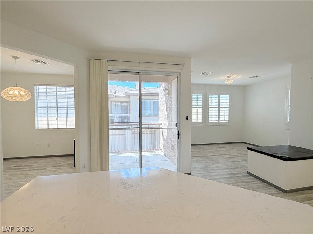 10221 Deerfield Beach Avenue, #202, Las Vegas, NV 89129 Sliding doors open to a private balcony, connecting the light-filled interior to the outdoors.