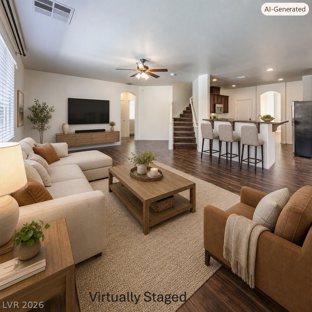 8132 Pink Desert Street, North Las Vegas, NV 89085 An inviting open-concept living area flows seamlessly into the kitchen, showcasing rich hardwood flooring and a stylish breakfast bar. This area has been Virtually Staged using AI and is for inspiration only.