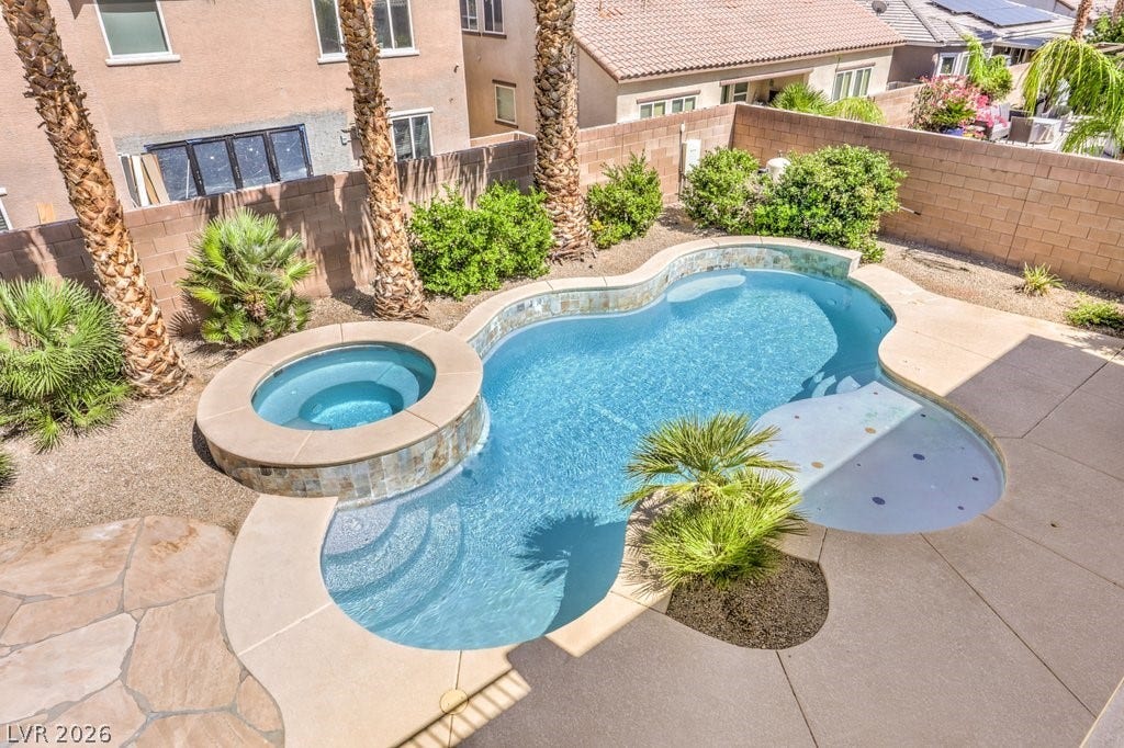 8132 Pink Desert Street, North Las Vegas, NV 89085 An inviting backyard oasis awaits with a sparkling pool and spa, perfect for relaxation.