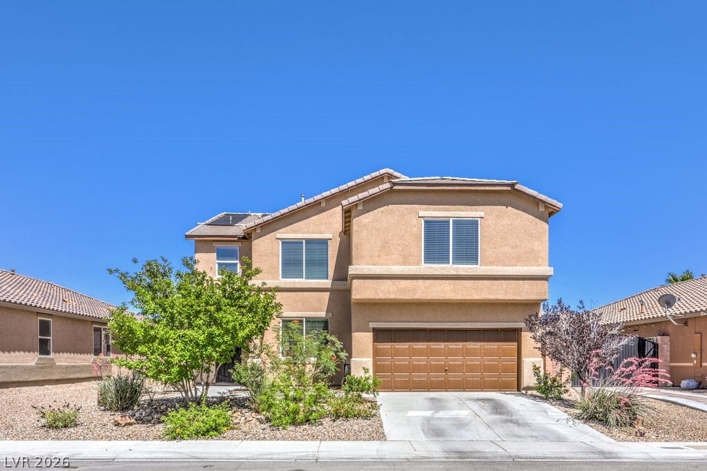 8132 Pink Desert Street, North Las Vegas, NV 89085 A traditional two-story residence with a desert-friendly front yard landscape and integrated garage awaits.
